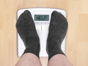 Man feet on weight loss scales