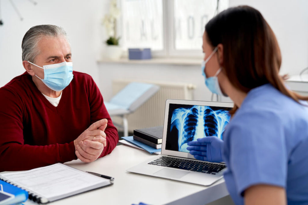 doctor discussing x-ray lung cancer images with patient