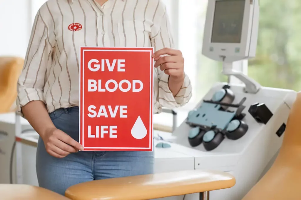 How Much Blood Donation Benefits Health - Woman holding a sign says Blood Donation Save Life