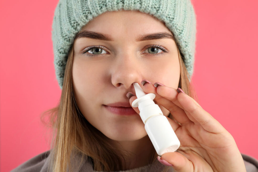 Treatment for Allergy in Cold Weather - Woman is Using an Antihistamine Nasal Spray